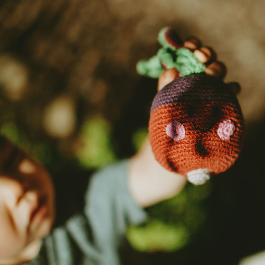 Toddler holding up Handmade Crochet Cotton Beet Rattle