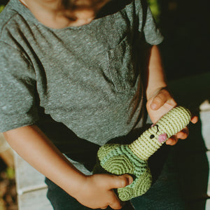 Toddler holding Green Plush Broccoli Rattle