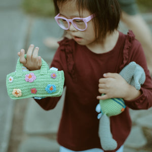 Girl looking at Handmade Fair Trade Cotton Easter Bag with crochet flowers