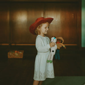 Girl holding Cow and Cowboy Doll