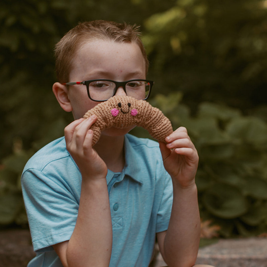 Boy holding croissant plush toy 