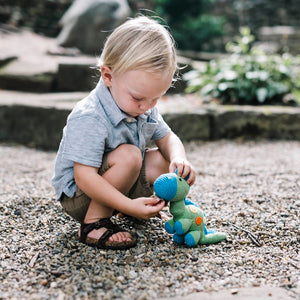 Boy playing with handmade croceht green and blue dino
