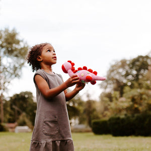 Girl holding handmade crochet dino toy