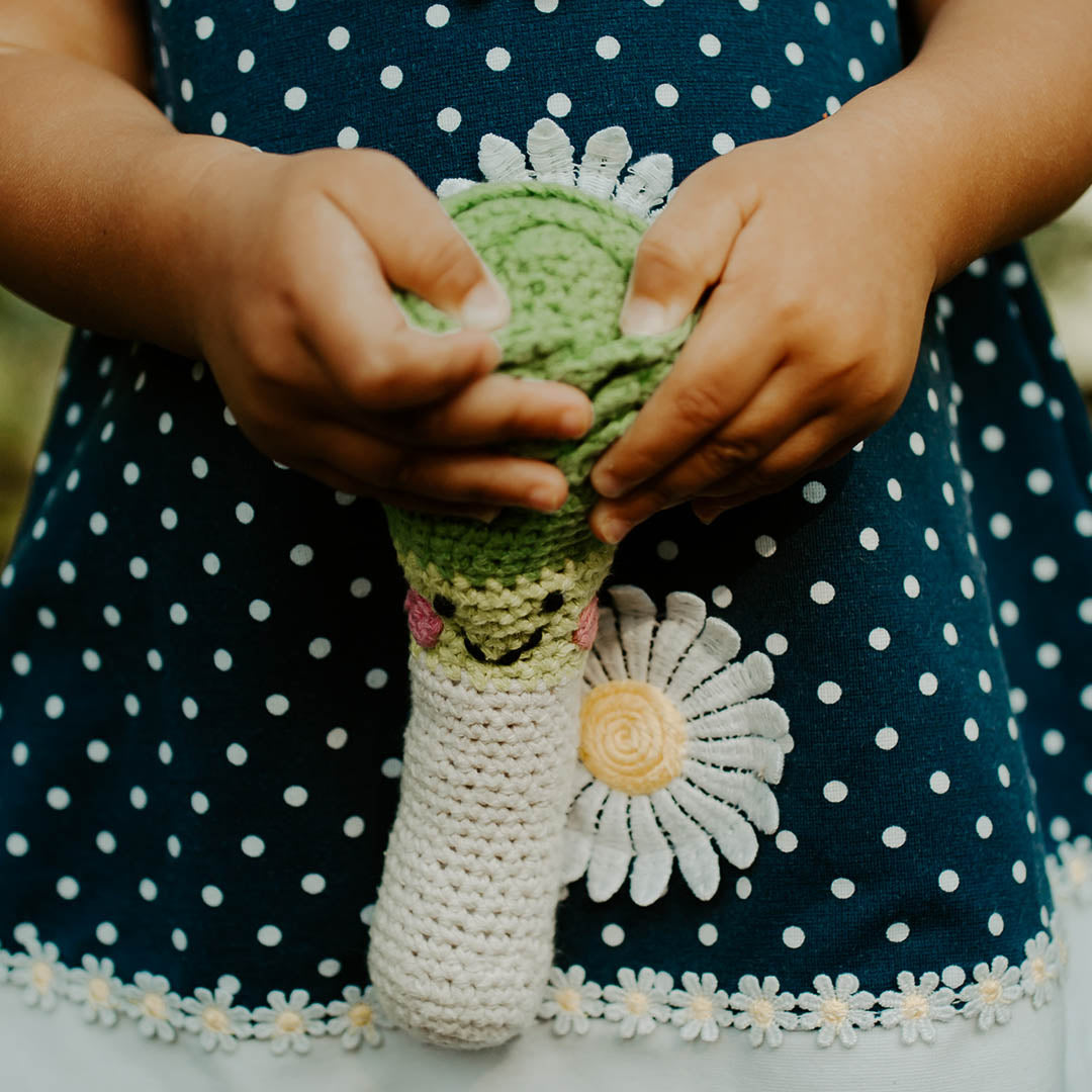 Child holding Green and White Friendly Leek Soft Toy Rattle