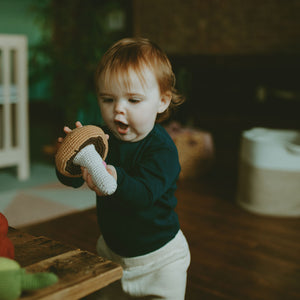 Toddler with handmade crochet brown mushroom plush toy