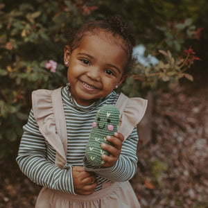 Girl with fair trade organic pickle soft baby toy