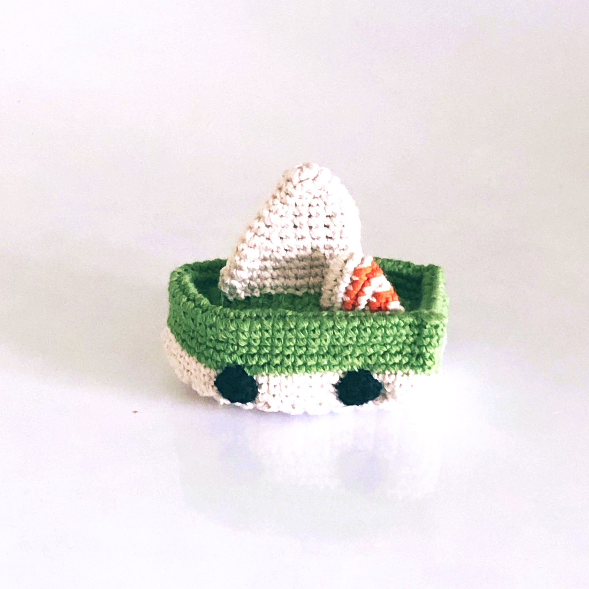 Green and white crochet plush sailboat toy rattle.