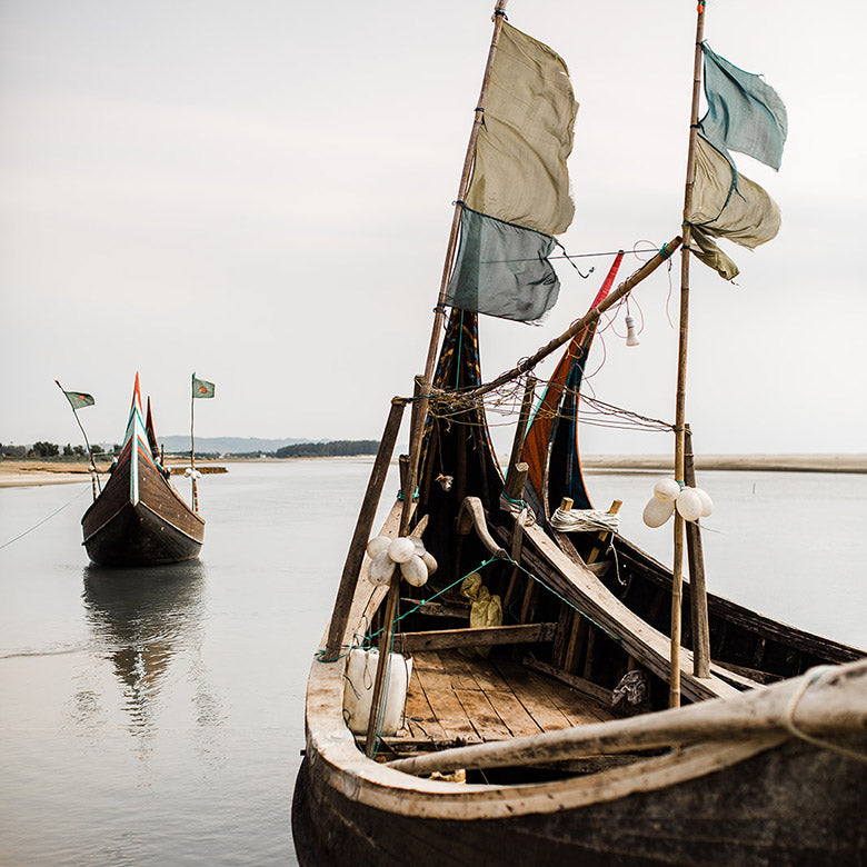 Three boats on the shores of a Bangladeshi river. Photo by Adrienne Gerber Photography