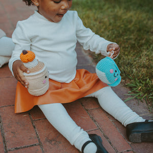 Girl playing with pumpkin spice latte and chai latte plush toy rattles