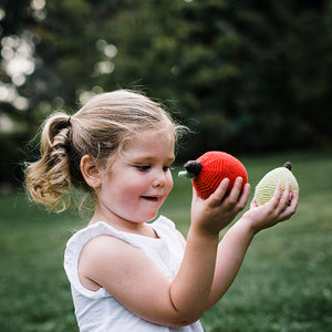 Girl holding crochet red apple and green pear