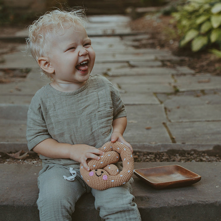 Boy laughing with handmade crochet ptretzel toy