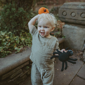 Toddler with Plush Black Spider and Pumpkin Rattle
