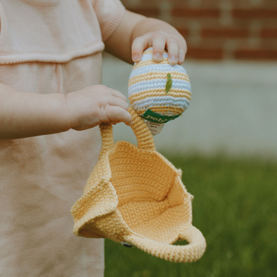 Girl taking Egg out of Crochet Handmade Yellow Easter Basket