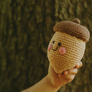 Toddler holding up Handmade Crochet Stuffed Toy Acorn