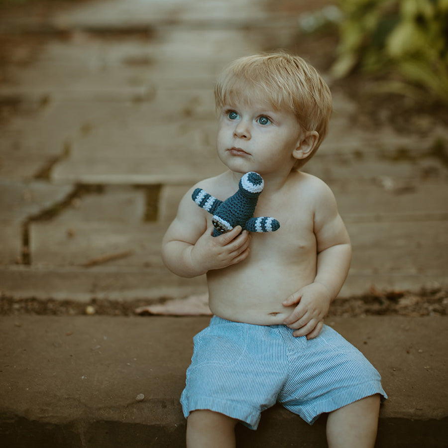 Boy holding handmade blue and white airplane toy.