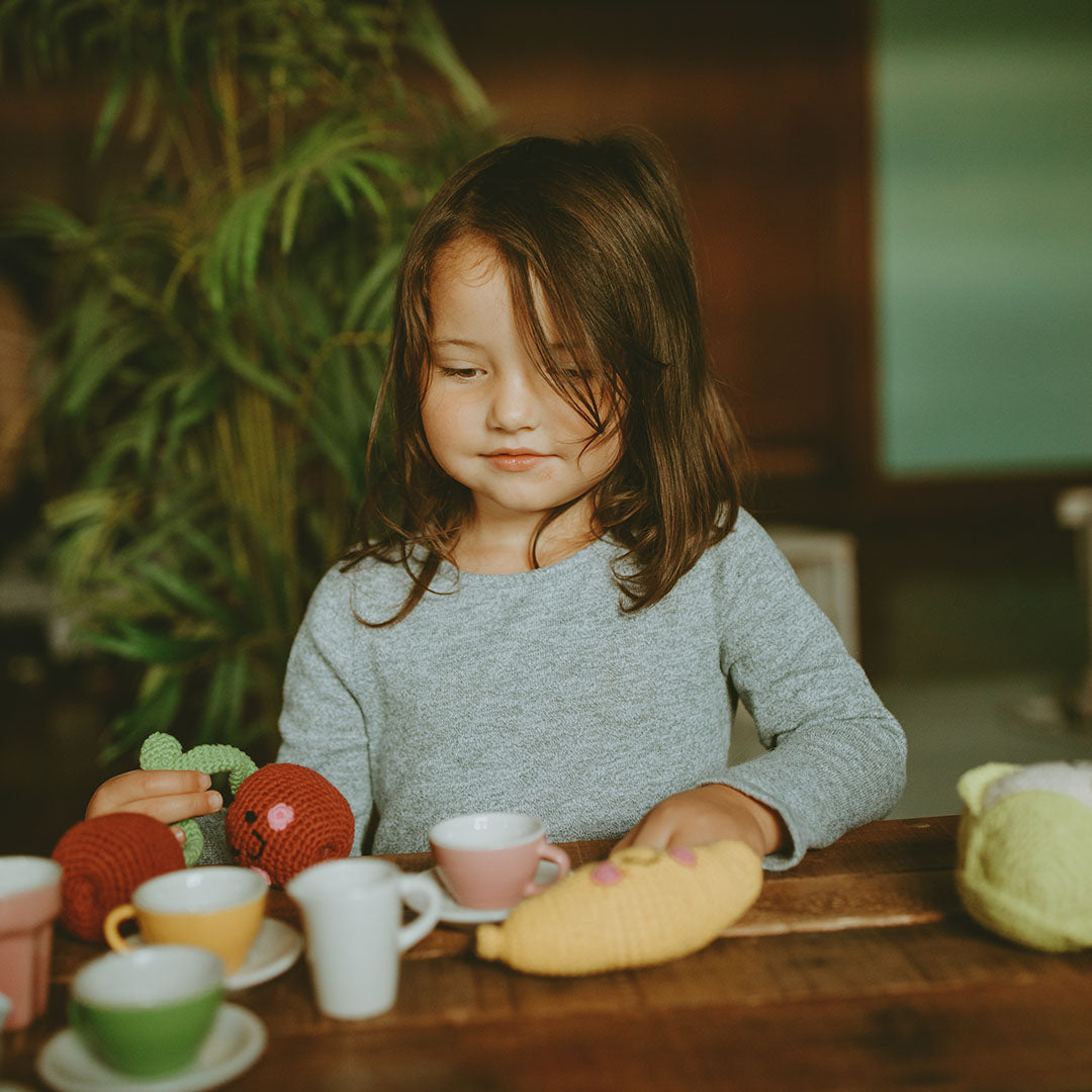 Girl having tea party with Banana Baby Toy