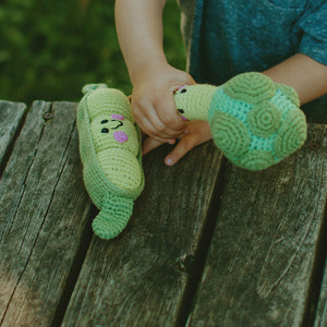 toddler playing with handmade crochet peapod and broccoli baby toys